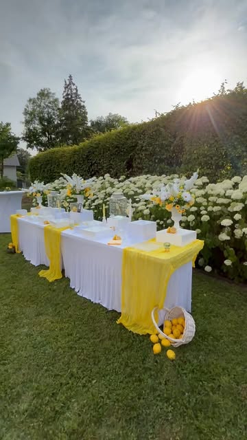 Tables blanches et jaunes installées dans un jardin